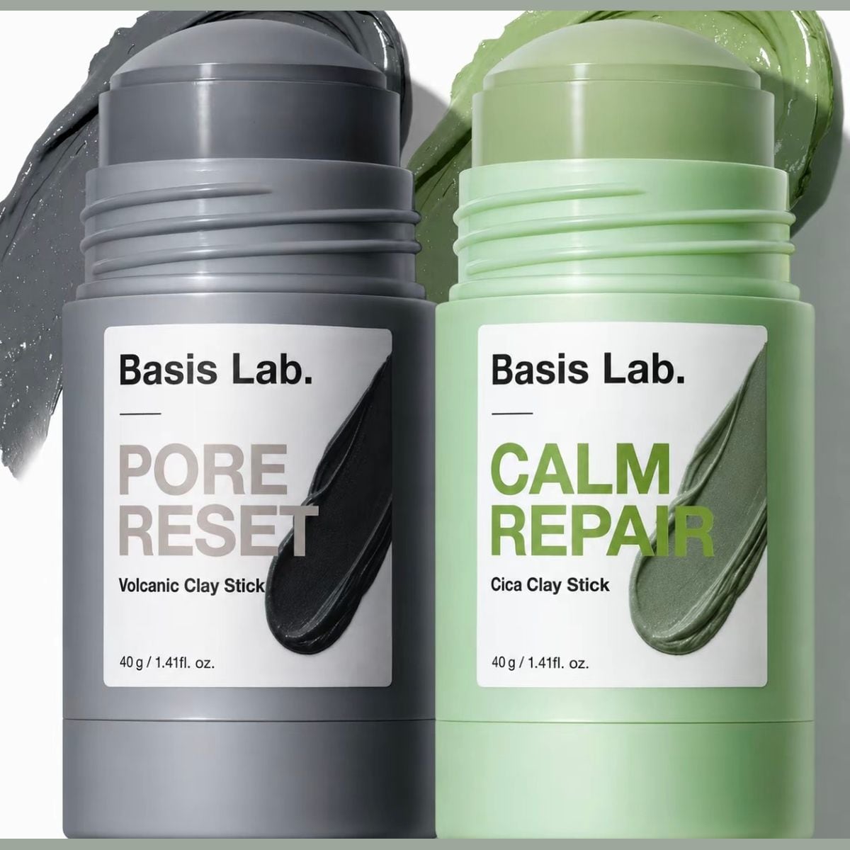 Grauer Basis Lab Pore Reset Stick mit vulkanischer Tonerde und grüner Calm Repair Stick mit Cica-Tonerde, je 40 g, dahinter Swatches beider Masken
