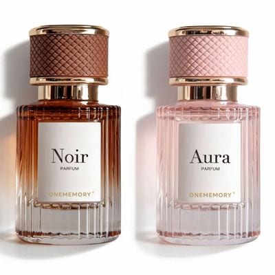 Zwei ONEMEMORY Parfumflakons nebeneinander: Noir mit brauner strukturierter Kappe und Aura mit rosa strukturierter Kappe